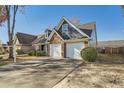 Beautifully landscaped home showcasing a well-kept lawn, mature trees, and a two-car garage in a suburban setting at 1756 Hedington Ct, Lawrenceville, GA 30045