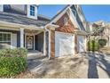 Close-up of the home's entrance, highlighting the brickwork, two-car garage, and charming front porch at 1756 Hedington Ct, Lawrenceville, GA 30045