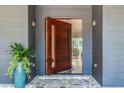 Stunning modern front door with glass insert, sidelights, stone flooring, and a lush potted plant at 3117 W Roxboro Ne Rd, Atlanta, GA 30324