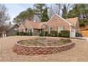 Landscaped front yard with brick retaining wall and driveway leading to attached garage at 2895 Dogwood Creek Pkwy, Duluth, GA 30096