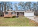 Charming single-story home with brick accents, siding, attached garage, and a well-maintained lawn at 4446 Frontier Way, Sugar Hill, GA 30518