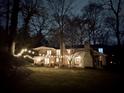Stunning home exterior with string lights across the yard at night at 192 Maple Wood Dr, Lawrenceville, GA 30046