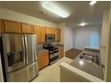 Kitchen with stainless steel appliances, wood cabinets, and sink at 1696 Tailmore Ln, Lawrenceville, GA 30043