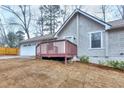 View of the side of the home featuring a wooden porch and large 2 car garage at 2370 Old Mill Sw Dr, Conyers, GA 30094