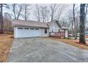 Inviting home exterior with large driveway, attached garage, and covered porch at 2370 Old Mill Sw Dr, Conyers, GA 30094