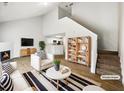 Bright, staged living room featuring a fireplace, hardwood floors, and vaulted ceilings at 180 Fieldview Ln, Covington, GA 30016