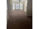 Spacious living room with carpet, three large windows, and a ceiling fan at 8170 Oakley Cir, Union City, GA 30291