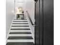 Elegant staircase featuring contrasting black treads and white risers, complemented by modern decor at 482 Pearl Cove Ct, Atlanta, GA 30350