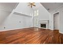 Well-lit living room featuring hardwood floors, a fireplace, and large windows that enhance the space at 5065 Avalon Dr, Alpharetta, GA 30005