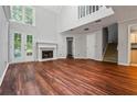 Spacious living room with a fireplace, hardwood floors, and natural light from the doors to the backyard at 5065 Avalon Dr, Alpharetta, GA 30005