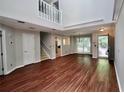 Spacious living room with hardwood floors, staircase, and large windows that let in ample natural light at 5065 Avalon Dr, Alpharetta, GA 30005