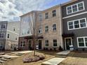 Three-story townhomes featuring a variety of neutral sidings and brick, each with a black front door at 5459 Blossomwood Sw Trl, Mableton, GA 30126