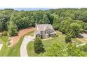 Expansive aerial shot of a two-story home with lush greenery, a long driveway, and mature trees at 135 Waterlace Way, Fayetteville, GA 30215
