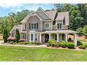 Charming two-story home with a covered porch, brick accents, and professionally landscaped front yard at 135 Waterlace Way, Fayetteville, GA 30215