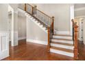 Elegant foyer with hardwood floors, staircase with iron spindles, and classic white trim at 135 Waterlace Way, Fayetteville, GA 30215