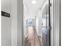 Hallway featuring hardwood floors that lead into a bright living space with balcony access and natural light at 3040 Peachtree Nw Rd # 613, Atlanta, GA 30305