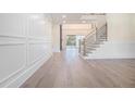 Spacious foyer with hardwood floors, paneled accent walls, and an elegant staircase with metal railing at 4332 Kay Morgan Rd, Buford, GA 30519