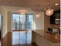 Bright living area features a modern chandelier, wood floors, and expansive windows with impressive city views at 1080 Peachtree Ne St # 2915, Atlanta, GA 30309