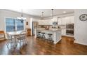 Bright kitchen with white cabinets, granite countertops, stainless steel appliances and a large island at 3890 Pleasant Woods Dr, Cumming, GA 30028