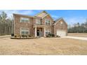 Charming two-story brick home featuring a manicured lawn and attached two-car garage at 10 Tabor Trce, Oxford, GA 30054