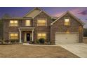 Charming two-story brick home featuring a manicured lawn and attached two-car garage at 10 Tabor Trce, Oxford, GA 30054