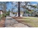 A bright, white-painted bungalow-style house with dark shutters and a concrete driveway at 895 Mercury Nw Dr, Atlanta, GA 30331