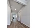 Bright hallway with hardwood floors leading into a well-lit living space with a kitchen beyond at 3614 Arrow Root Cir, Loganville, GA 30052