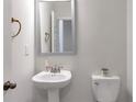 Well-lit powder room with pedestal sink, toilet, and modern fixtures at 2989 Chene Pl, Duluth, GA 30097