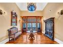 Grand foyer featuring custom wood trim, a chandelier, hardwood floors, and antique furniture exudes timeless elegance at 4001 Pool Rd, Winston, GA 30187