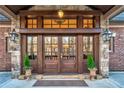 Stunning front entrance with a custom wood door, stone accents, and decorative lighting create a welcoming first impression at 4001 Pool Rd, Winston, GA 30187