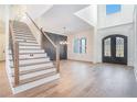 Grand foyer with staircase, hardwood floors, ornate black double doors, and soaring ceilings at 3825 Hall Rd, Dacula, GA 30019