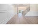 Elegant foyer boasting hardwood floors, wainscoting, and a modern staircase with metal railing at 3825 Hall Rd, Dacula, GA 30019