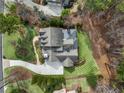 An aerial shot showcasing a meticulously landscaped yard, elegant home, and private wooded surroundings at 4388 Lochsa Ln, Suwanee, GA 30024