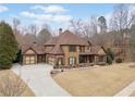 An exterior elevation showcases a large house with a three car garage, a long driveway and a well kept lawn at 829 Waterford Estates Mnr, Canton, GA 30115