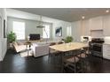 Bright, open-concept living room, kitchen and dining area features modern decor and lots of natural light at 10625 Serenbe Ln # 208, Chattahoochee Hills, GA 30268