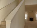 Bright entryway featuring a carpeted staircase and view into the living room with fireplace at 158 Weatherstone Dr, Woodstock, GA 30188
