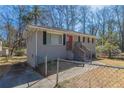 Grey brick home with a red door featuring a fenced yard and concrete walk and driveway at 2202 Polar Rock Sw Pl, Atlanta, GA 30315