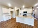 Open kitchen with granite countertops, white cabinets, and stainless steel appliances at 2407 Malster Ln, Lawrenceville, GA 30043