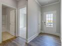 Bright entryway featuring hardwood floors, white trim, and doorways leading to various rooms at 76 Lakeview Pt, Dallas, GA 30157