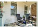 Relaxing porch setting with comfortable rocking chairs and a quaint outdoor rug at 122 Brighton Blvd, Woodstock, GA 30188