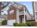 Side view showcasing brick accents, light siding, covered entryway, and manicured bushes at 6336 Lake Valley Pt, Lithonia, GA 30058