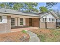 Brick home with covered front porch and lush landscape walkway leading to front door at 3339 Brenda Ln, Lithia Springs, GA 30122
