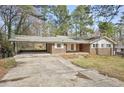 Angle view of a brick home featuring a covered carport and well kept lawn at 3339 Brenda Ln, Lithia Springs, GA 30122
