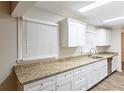 Kitchen area with granite countertops, white cabinets, and stainless steel dishwasher at 2800 Kingston Ter, Atlanta, GA 30344