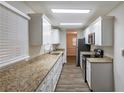 Galley kitchen featuring white cabinetry, granite countertops, and stainless steel appliances at 2800 Kingston Ter, Atlanta, GA 30344