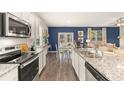 Open concept kitchen with white cabinets, granite countertops, stainless steel appliances and an island at 221 Friendship Oak Way, Hampton, GA 30228