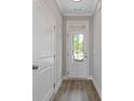 Bright hallway featuring wood-look flooring, a door with glass panes, and neutral-toned walls at 1985 William Glen St, Dacula, GA 30019