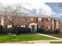 Charming two-story brick townhome with a manicured front lawn, bench, and welcoming entrance at 3535 Roswell Ne Rd # H2, Atlanta, GA 30305
