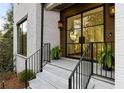 Inviting front porch with black iron railing and a modern glass front door at 5060 Lake Forrest Dr, Atlanta, GA 30342