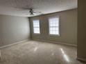 Neutral bedroom with two windows, ceiling fan, and plush carpeting at 6420 Phillips Pl, Lithonia, GA 30058